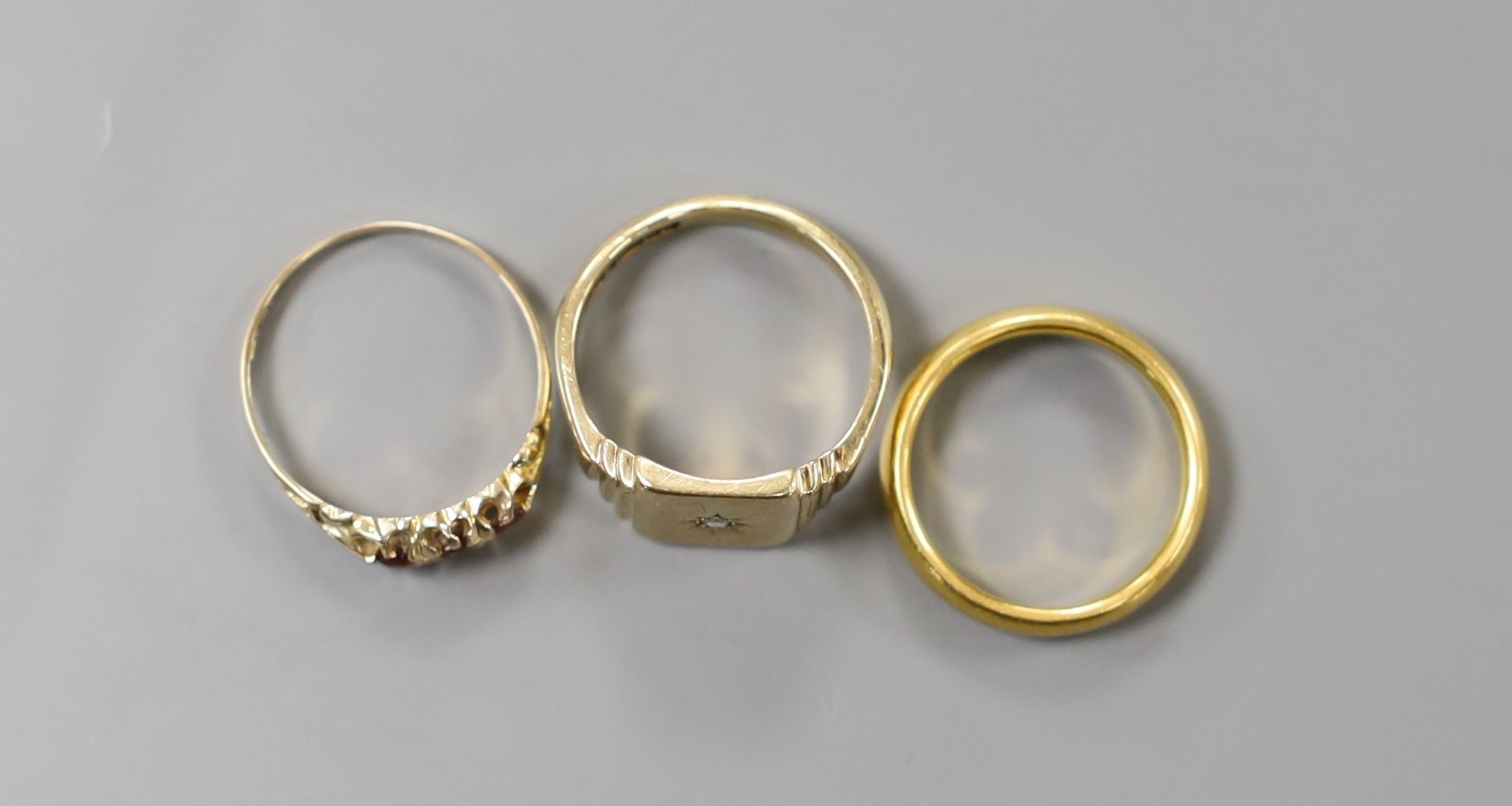 An early 1930's 22ct gold wedding band, size N/O, 7.1 grams and two 9ct gold rings including a mid 20th century diamond set signet ring, gross 8 grams.